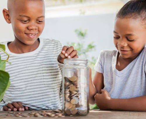 Young african male and female throwing coins into a jar together.